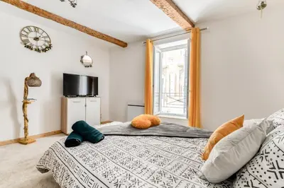 a bedroom with a bed and a window at Soleil Sucré T2 Centre historique de Narbonne in Narbonne