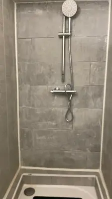 a shower with a shower head and a toilet in a bathroom at L'Alcove in Carcassonne