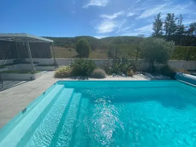 a swimming pool with blue water in a yard at Le point BE - Magnifique villa avec piscine chauffée - de mai à septembre - pour 6 personnes in Ornaisons
