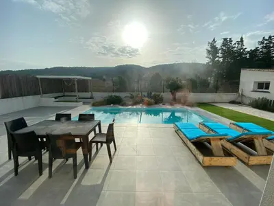 a patio with a table and chairs and a pool at Le point BE - Magnifique villa avec piscine chauffée - de mai à septembre - pour 6 personnes in Ornaisons