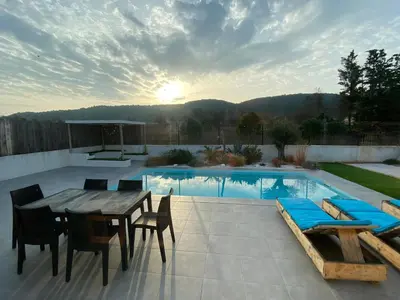 a patio with a table and chairs and a pool at Le point BE - Magnifique villa avec piscine chauffée - de mai à septembre - pour 6 personnes in Ornaisons