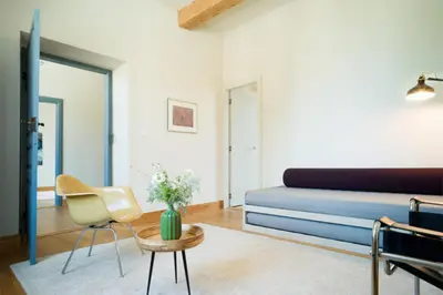 a living room with a bed and a table and chairs at Dépendance de Sibra in Lagarde