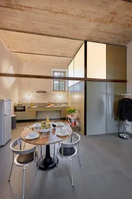 a kitchen with a table and chairs and a refrigerator at Dépendance de Sibra in Lagarde