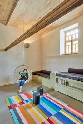 a woman sitting in a swing in a room at Dépendance de Sibra in Lagarde