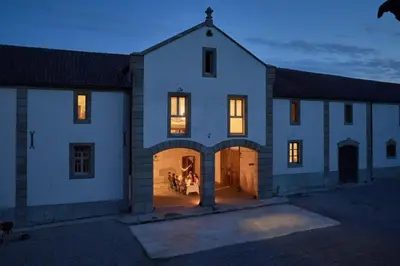a large white house with an archway at night at Dépendance de Sibra in Lagarde