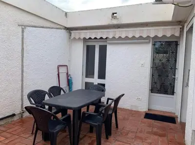 a black table and chairs on a patio at Patio avec cour et place de parking en bord de mer in Port-la-Nouvelle