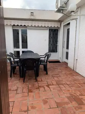 a black table and chairs on a patio at Patio avec cour et place de parking en bord de mer in Port-la-Nouvelle