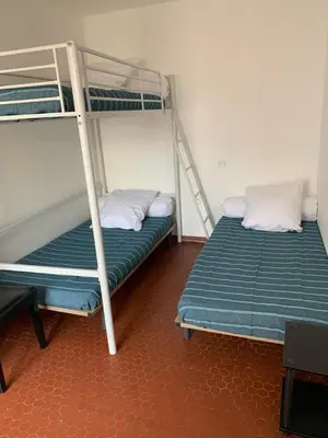 two bunk beds are in a room withthritisthritisthritisthritisthritisthritisthritisthritis at Patio avec cour et place de parking en bord de mer in Port-la-Nouvelle