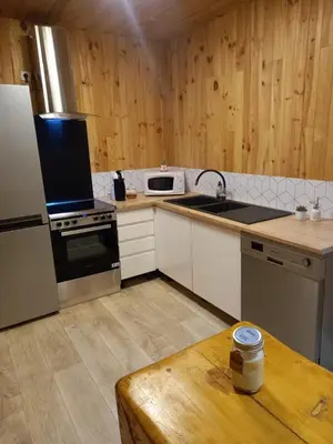a kitchen with a refrigerator and a stove top oven at Gîte l'Enclos Ô rendez-vous Roquefeuil-Pays de sault- avec jardin in Roquefeuil