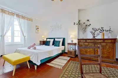 a bedroom with a bed and a chair in it at Les 2 Drôles d'Oiseaux in Luc-sur-Orbieu