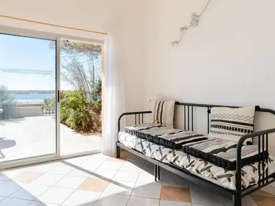 a bed in a room with a view of the ocean at Superbe Pavillon à Gruissan avec Terrasse sur Plage, 2 Chambres, Parking et Wifi - FR-1-409A-20 in Gruissan