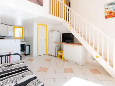 a kitchen with a staircase and a living room at Superbe Pavillon à Gruissan avec Terrasse sur Plage, 2 Chambres, Parking et Wifi - FR-1-409A-20 in Gruissan