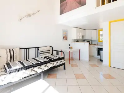 a living room with a couch and a kitchen at Superbe Pavillon à Gruissan avec Terrasse sur Plage, 2 Chambres, Parking et Wifi - FR-1-409A-20 in Gruissan