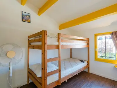 two bunk beds in a room with a fan at Superbe Pavillon à Gruissan avec Terrasse sur Plage, 2 Chambres, Parking et Wifi - FR-1-409A-20 in Gruissan