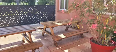 two wooden benches sitting next to a fence at DOMAINE DE POULHARIES - Carignan in Carcassonne