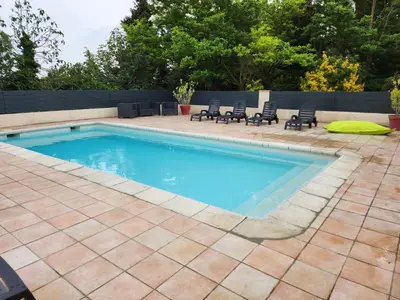 a swimming pool with a patio and chairs around it at DOMAINE DE POULHARIES - Carignan in Carcassonne