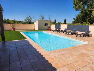 a swimming pool in a yard with chairs around it at DOMAINE DE POULHARIES - Carignan in Carcassonne