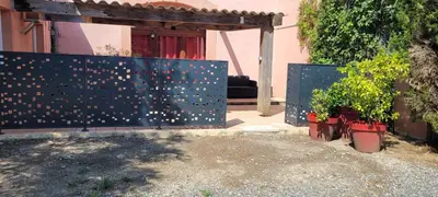 a fence with two potted plants in front of a house at DOMAINE DE POULHARIES - Carignan in Carcassonne
