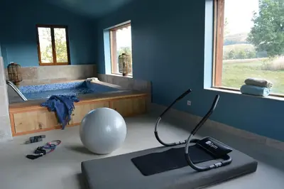 a room with a bath tub and a treadmill at Bastide des Tourelles pour 20 pers. Piscine & Spa in Marzens