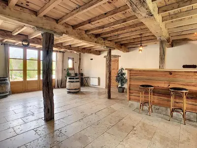 a large room with wooden beams and stools at Bastide des Tourelles pour 20 pers. Piscine & Spa in Marzens
