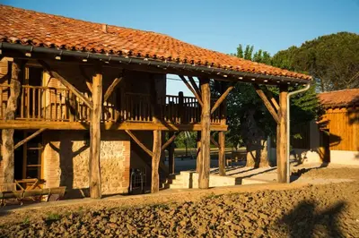 a wooden building with a deck on the side of it at Bastide des Tourelles pour 20 pers. Piscine & Spa in Marzens