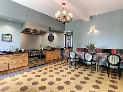a large kitchen with a dining table and chairs at Bastide des Tourelles pour 20 pers. Piscine & Spa in Marzens