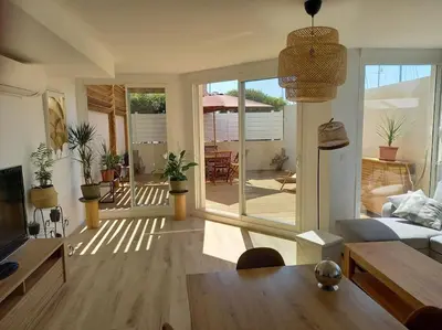 a living room with a couch and a table at Appartement 100 m2 Terrasse Piscine in Gruissan