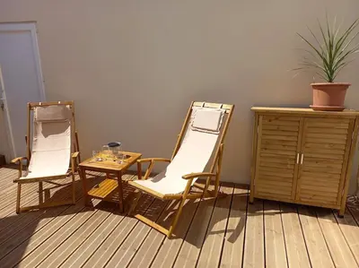 two chairs and a table in a room at Appartement 100 m2 Terrasse Piscine in Gruissan