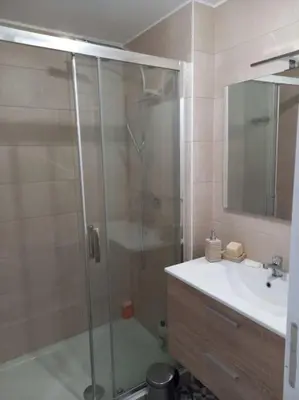 a bathroom with a glass shower and a sink at Appartement 100 m2 Terrasse Piscine in Gruissan