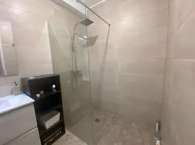 a shower with a glass door in a bathroom at Appartement 100 m2 Terrasse Piscine in Gruissan