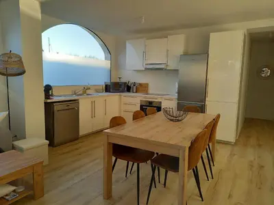 a kitchen with a wooden table and a dining room at Appartement 100 m2 Terrasse Piscine in Gruissan