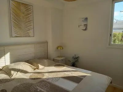 a bedroom with a bed in a room with a window at Appartement 100 m2 Terrasse Piscine in Gruissan