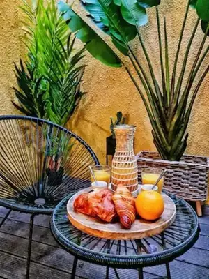 a table with a plate of food and a vase at Le Patio in Carcassonne