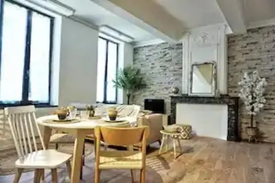 a living room with a table and chairs and a fireplace at Le Patio in Carcassonne