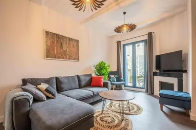 a living room with a couch and a table at Le Brodiaea Terrasse Wifi in Narbonne