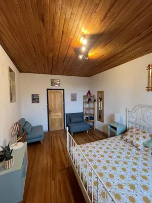 a living room with a bed and a couch at Les maisons de Gaïa Chambre d'hôte in Tuchan