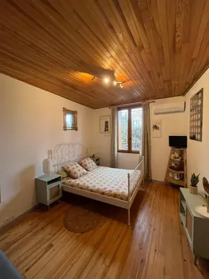 a living room with a bed and a couch at Les maisons de Gaïa Chambre d'hôte in Tuchan