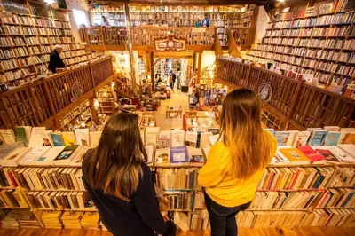 two women standing in a library looking at books at La Villa Nina in Mirepeisset