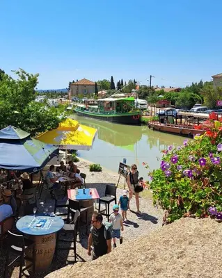 a group of people walking along a river with a boat at La Villa Nina in Mirepeisset