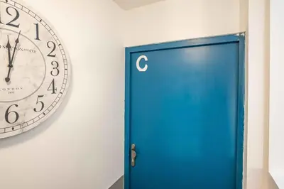 a clock on the wall next to a blue door at L'Apothicaire Proche des Halles in Narbonne