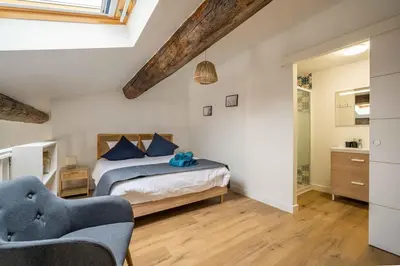a bedroom with a bed and two chairs at L'Apothicaire Proche des Halles in Narbonne