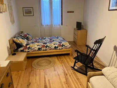 a living room with a bed and a chair in it at Chambres d'hôtes : Les maisons de Gaïa in Tuchan