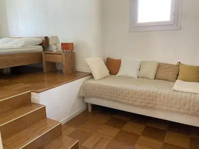 a living room with a couch and a bed at Maison familiale chaleureuse narbonne in Narbonne