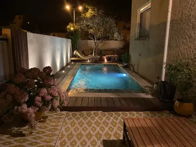 a small swimming pool in a backyard at night at Maison familiale chaleureuse narbonne in Narbonne