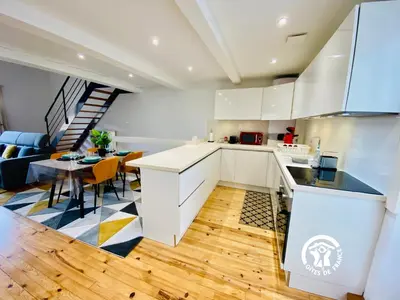 a kitchen and living room with a table and a couch at Loft cocon climatisé - Imprenable vue sur le château Comtal in Carcassonne