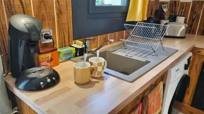 a kitchen counter with a laptop and cups on it at Appartement Signature - Design, Parking & Mer in Fitou