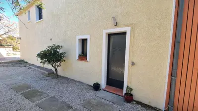 a building with a door and a window and a tree at Appartement Signature - Design, Parking & Mer in Fitou