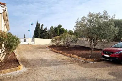 a car parked in a driveway next to a fence at Appartement Signature - Design, Parking & Mer in Fitou