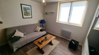 a living room with a couch and a table at Appartement Signature - Design, Parking & Mer in Fitou