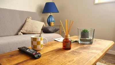 a wooden coffee table with a remote control on it at Appartement Signature - Design, Parking & Mer in Fitou